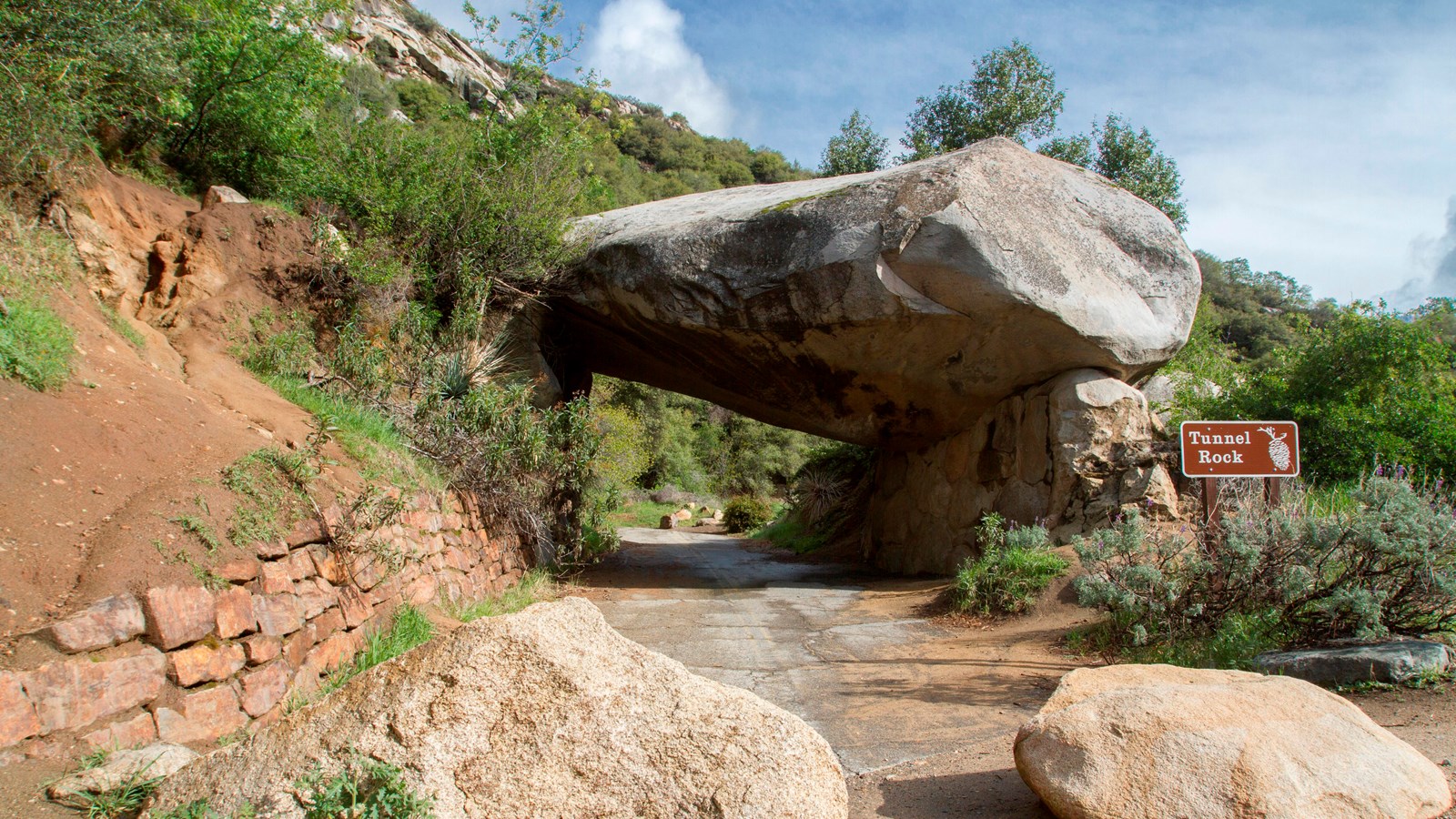 A large granite slab forms an arch as it balances on neighboring rock. A road one passed under here.