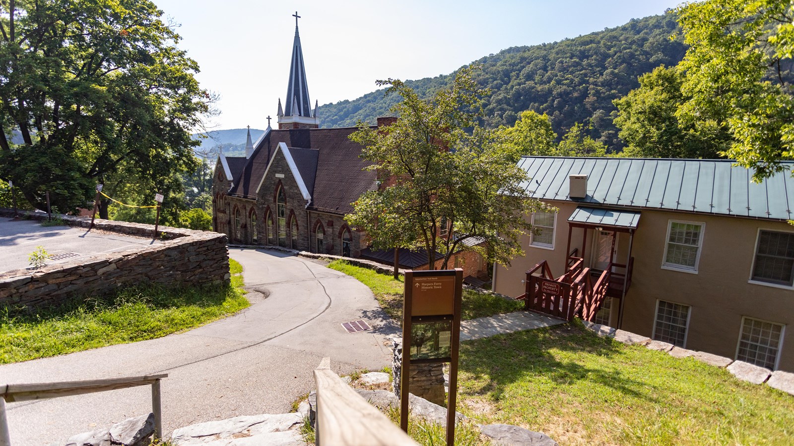 Foreground AT sign directing visitors to Harpers Ferry Historic Town, background view of church 