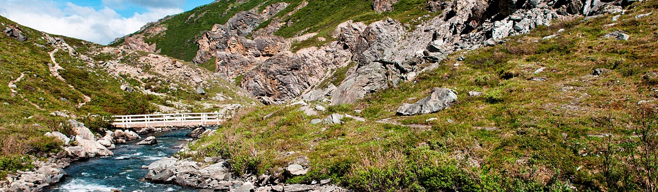 a shallow river flowing between mountains