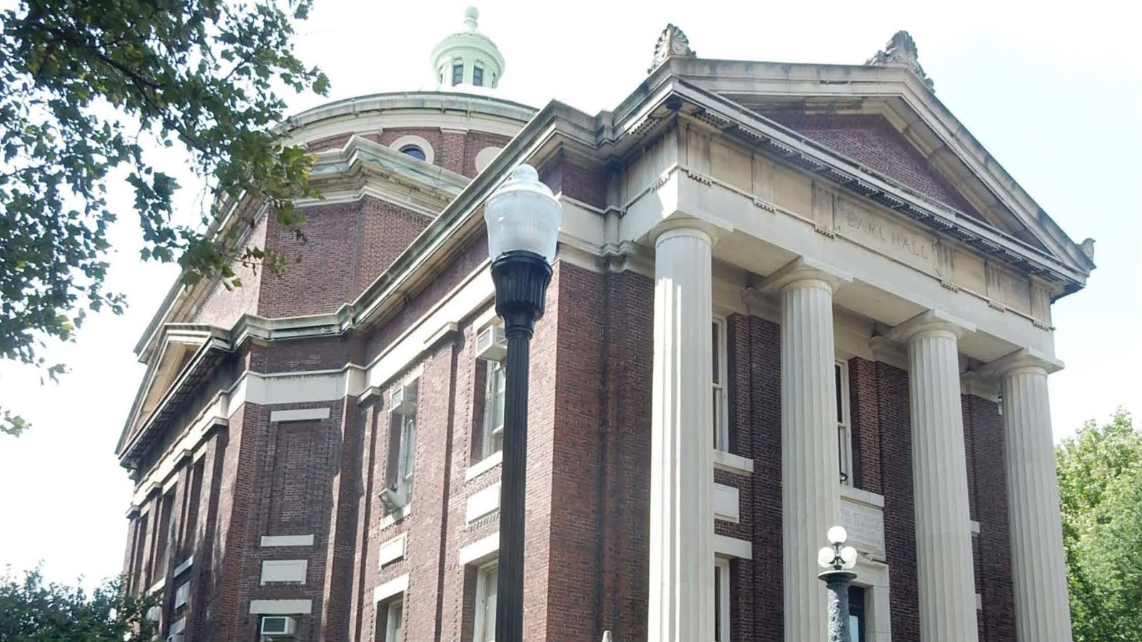 A three-story building built of red brick, it has a limestone portico and granite stairs