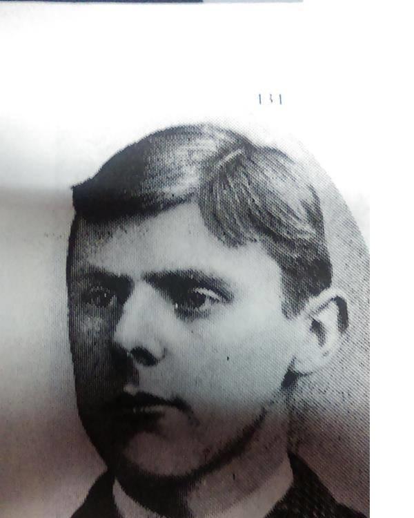 A man with dark hair parted on the side.