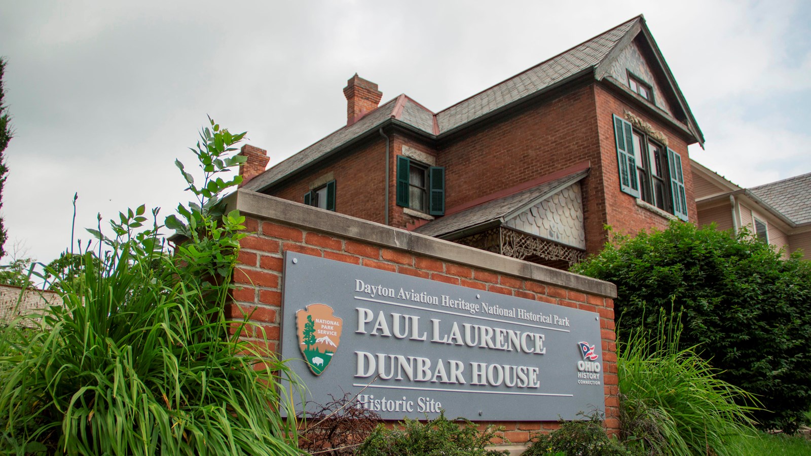 A sign reading Paul Laurence Dunbar House Historic Site in front of a brick house