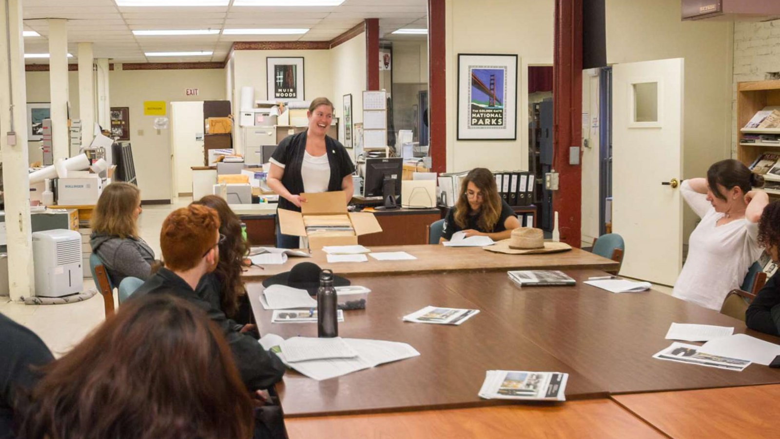 The archivist is making a presentation to a group of interns on doing research at the Park Archives.