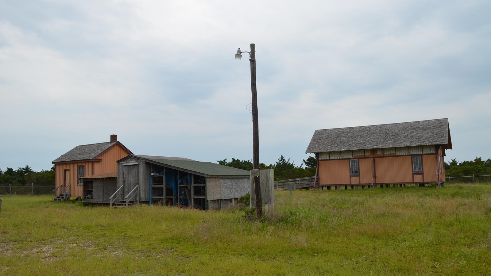 small outbuildings in foreground, boathouse in background