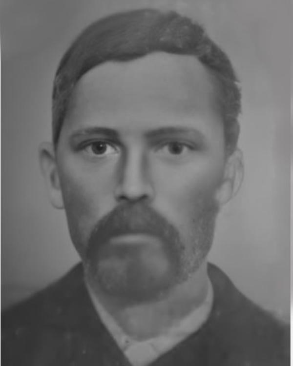 Black and white portrait of a mulatto man with dark short hair with a mustache style goatee.
