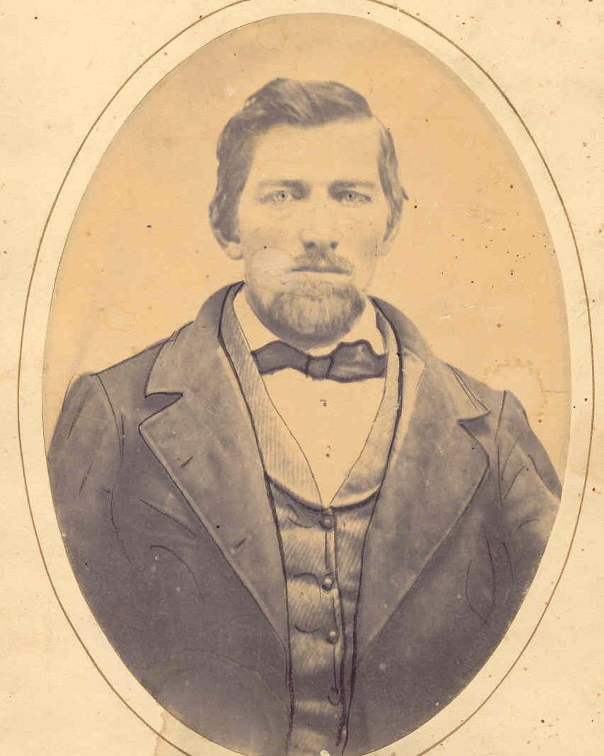 Man wearing a suit and bowtie posing for a photo. 