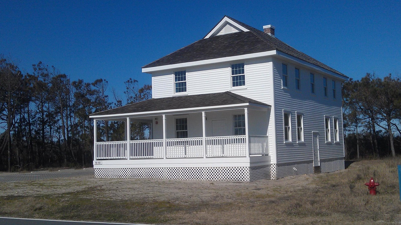 White Building in front of a tree line