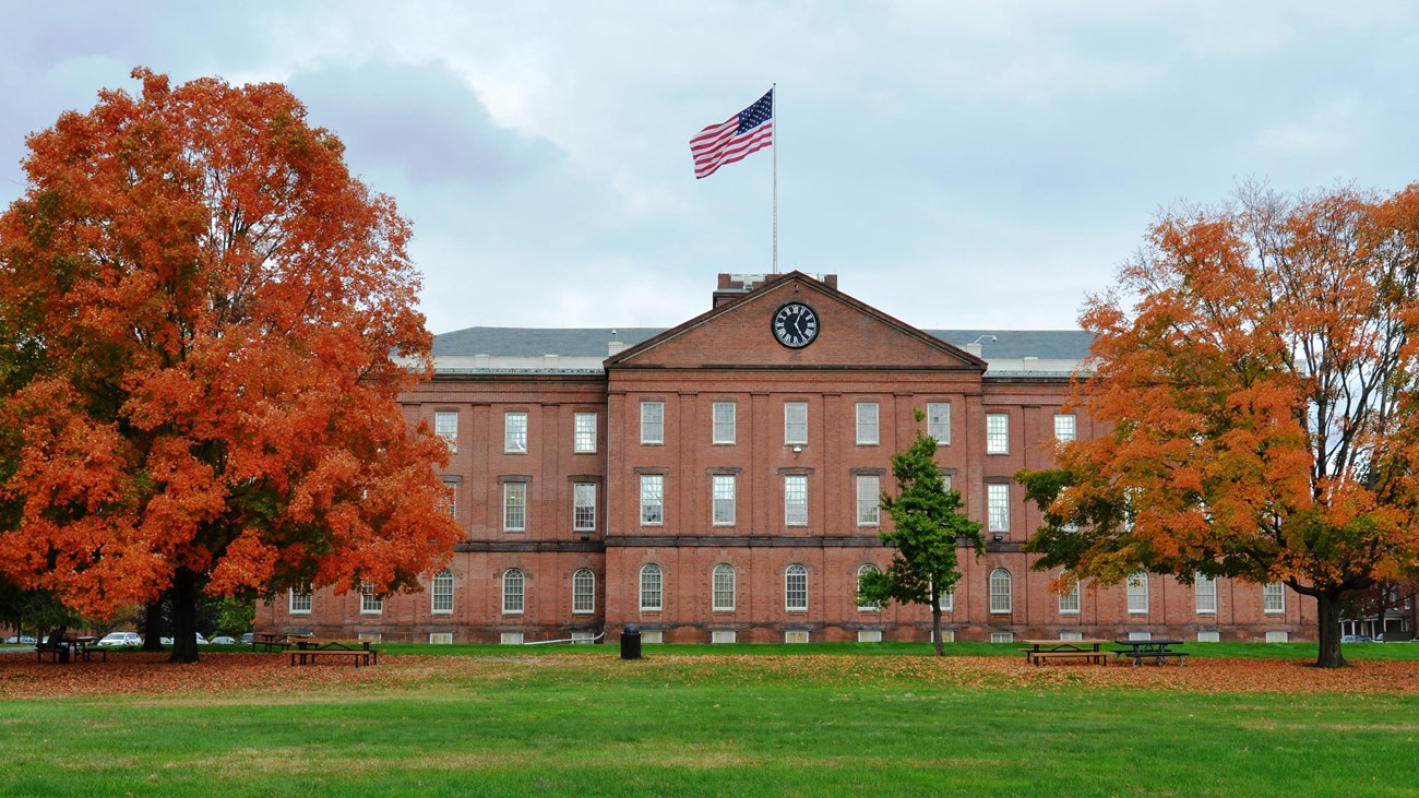 Springfield Armory set behind two colorful trees in fall. 