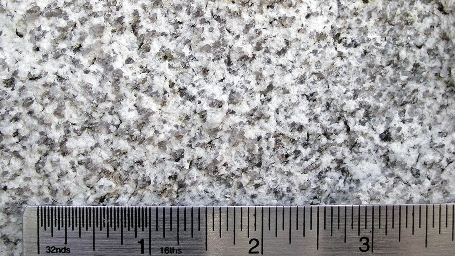 Close up of Almo Pluton with a ruler for scale, particles are about 2-4 mm.
