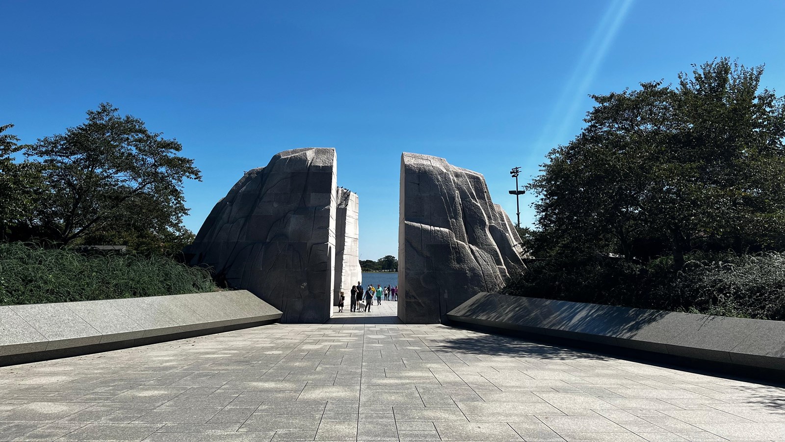 Two large structures flanked by grassy knolls and a cement walkway