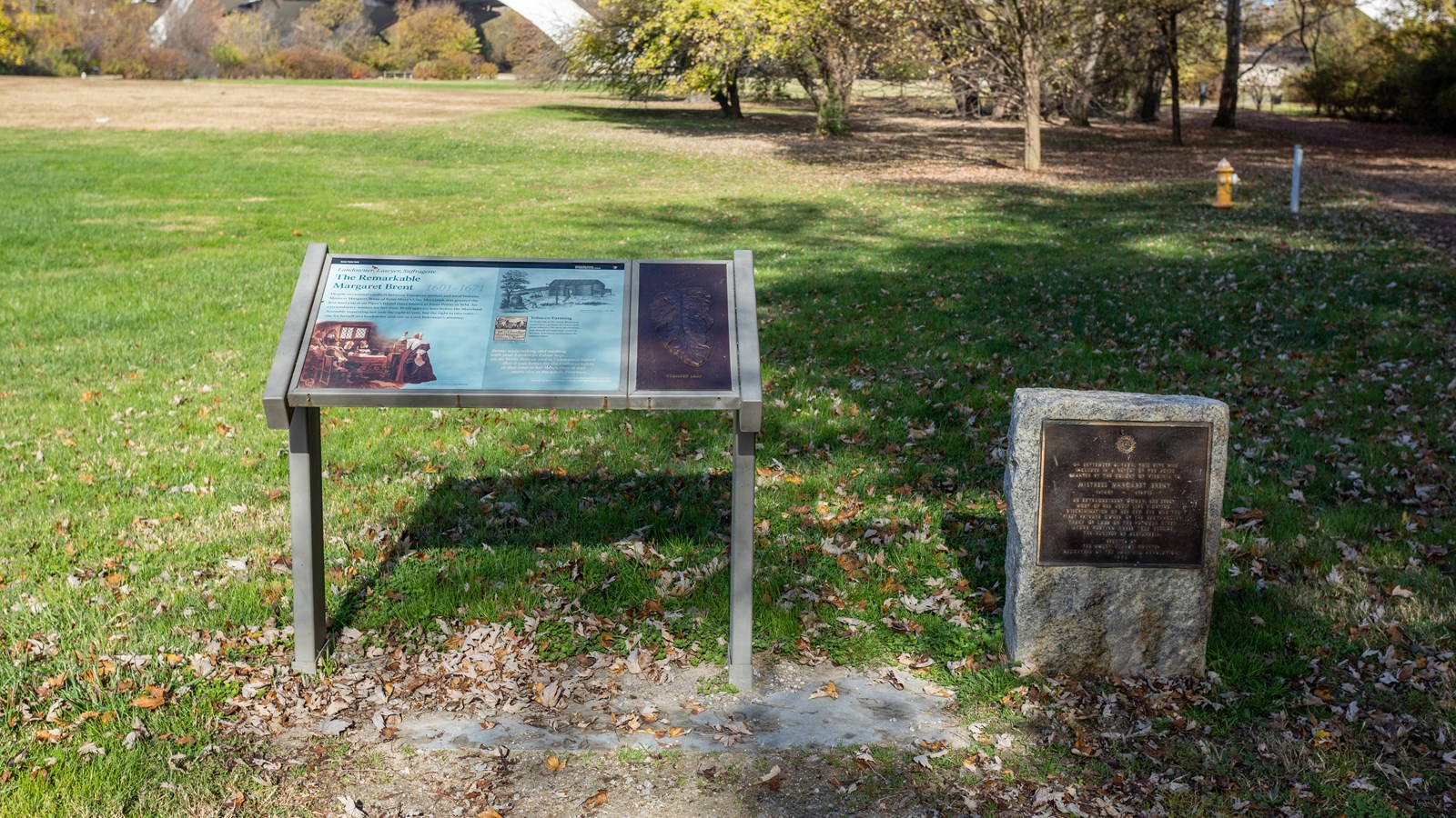 An information panel next to a small stone marker with bronze plaque.