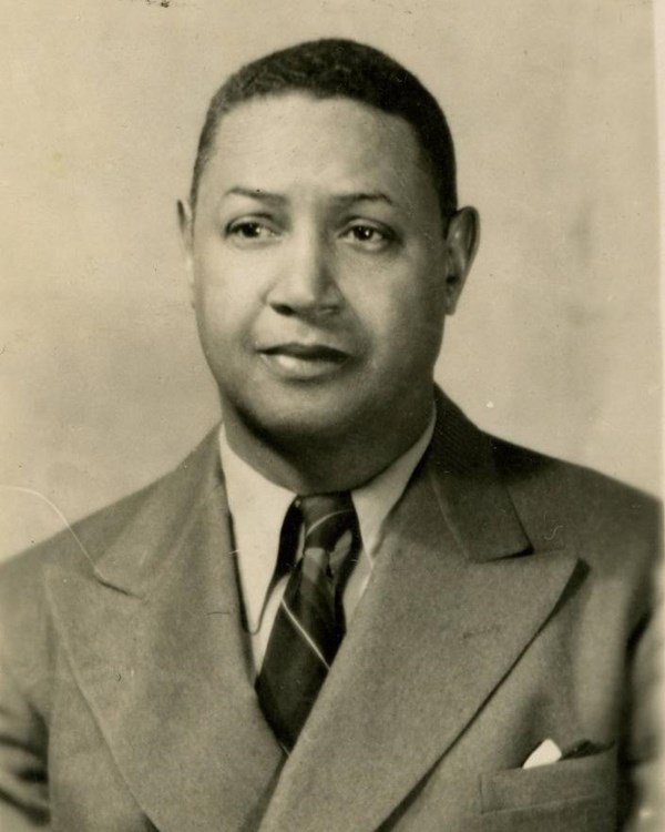 Black and white photograph of African American man in a suit. Photo is from the chest up.