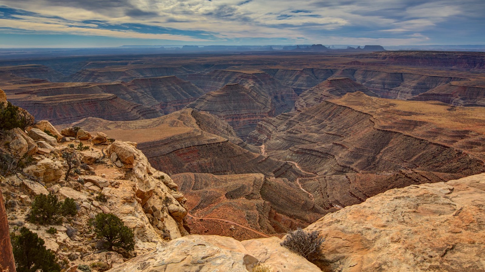 Sandstone canyons overlooking stepped canyon, with butte in the distance