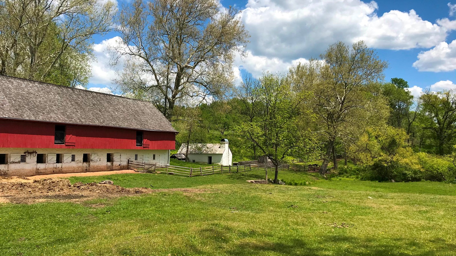 open field to the right of red wood barn animal stalls seen on first level stone painted white
