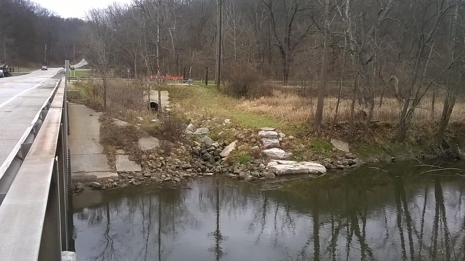 Next to a bridge is a thin, grassy trail that leads down to the Cuyahoga River