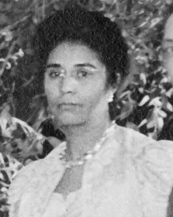 African American Woman profile picture in white dress with hair in a bun.