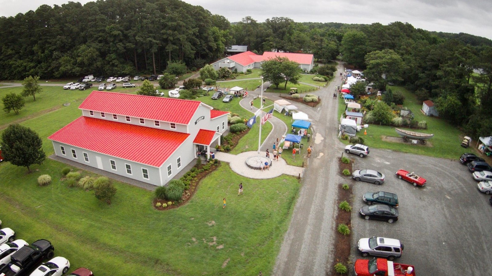 Aerial view of the museum building with parking lot, fields and trees surrounding