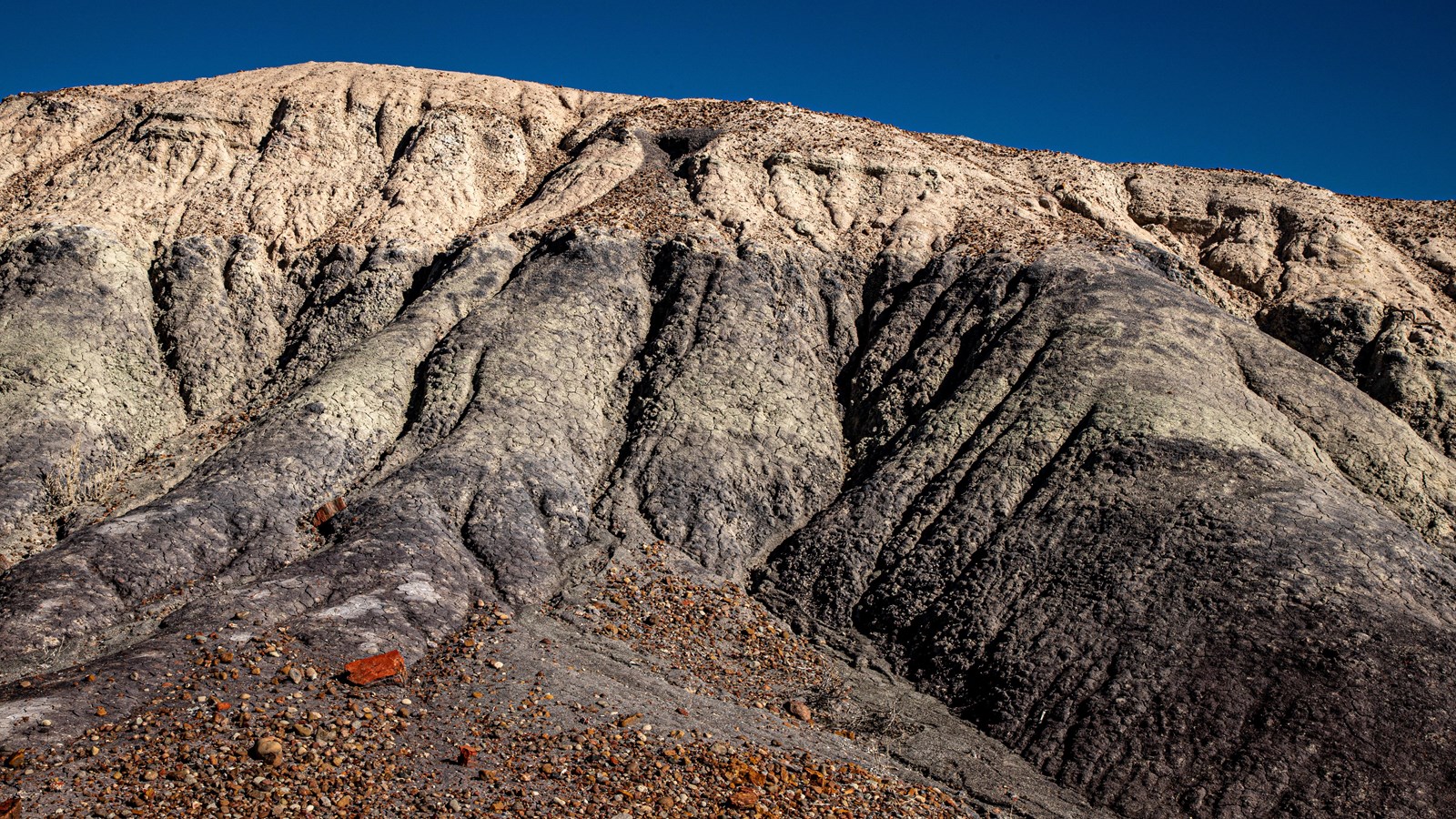 Blue and gray badland hill again blue sky