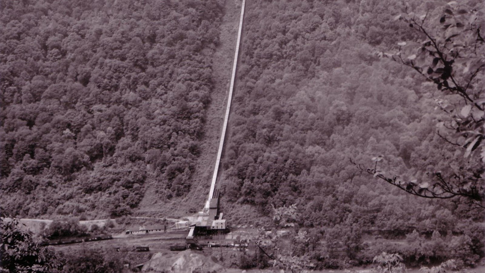 Historical photo of Brooklyn from across the river. A long conveyor runs down the steep gorge.