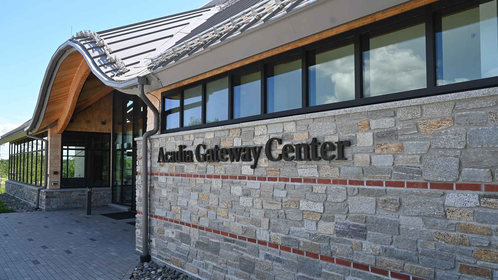 A stone building entrance with a sign that says Acadia Gateway Center