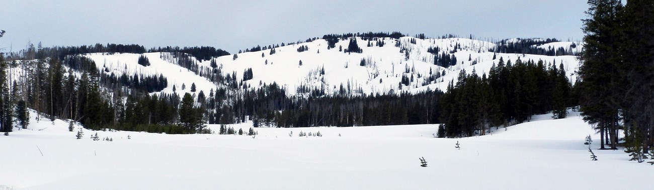 Hills suitable for backcountry skiing circle frozen and snow-covered Cascade Lake.