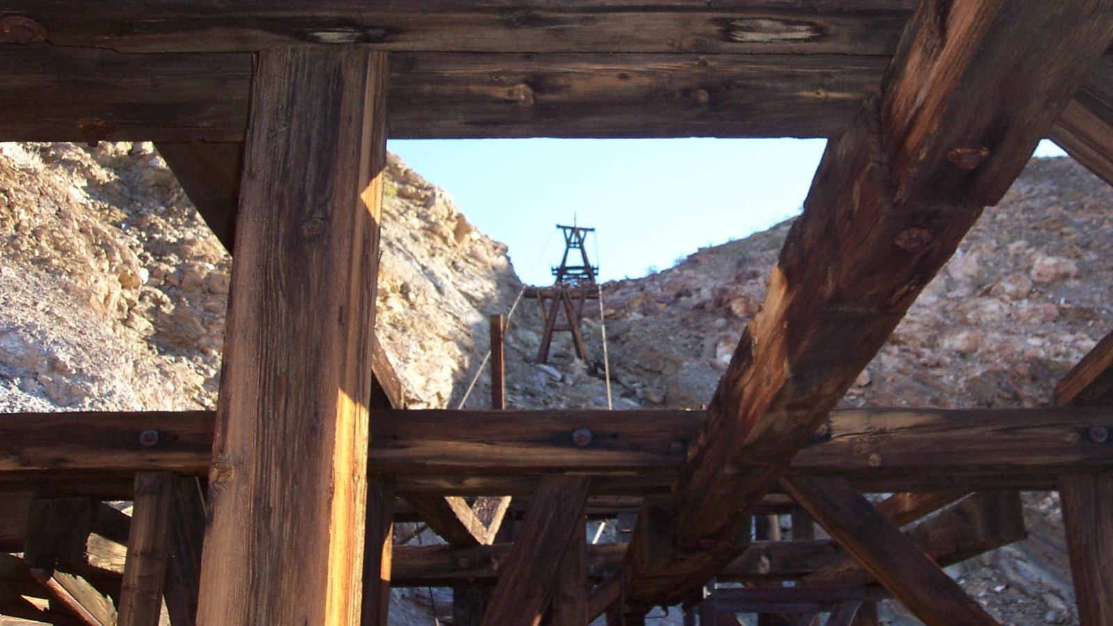 View of an aerial tramway tower through large wooden timbers.