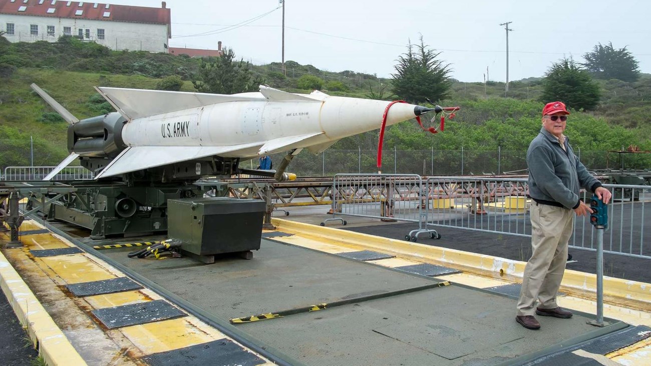 A volunteer demonstrates how a Nike missile rises from storage below ground.