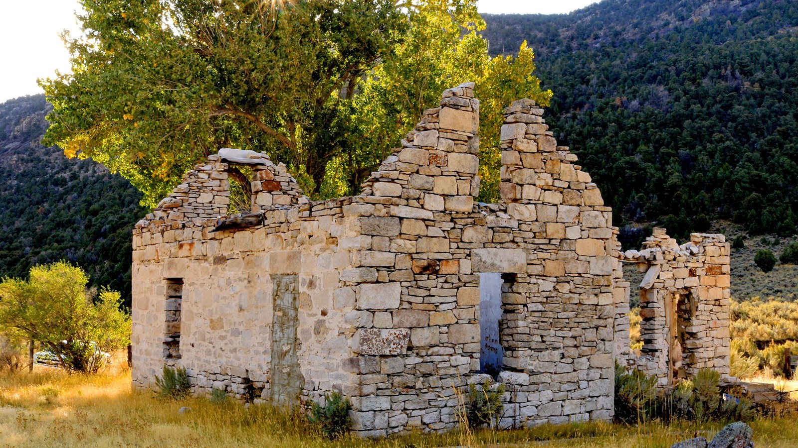 Ruins of a stone house with golden morning light.