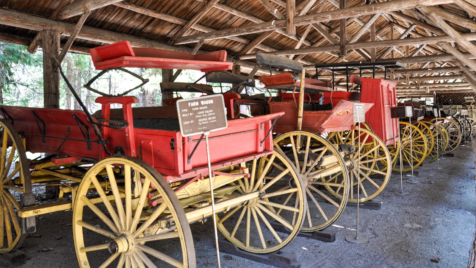 Carretas rojas e históricas del pasado de Yosemite están alineadas para ser vistas por el público. 
