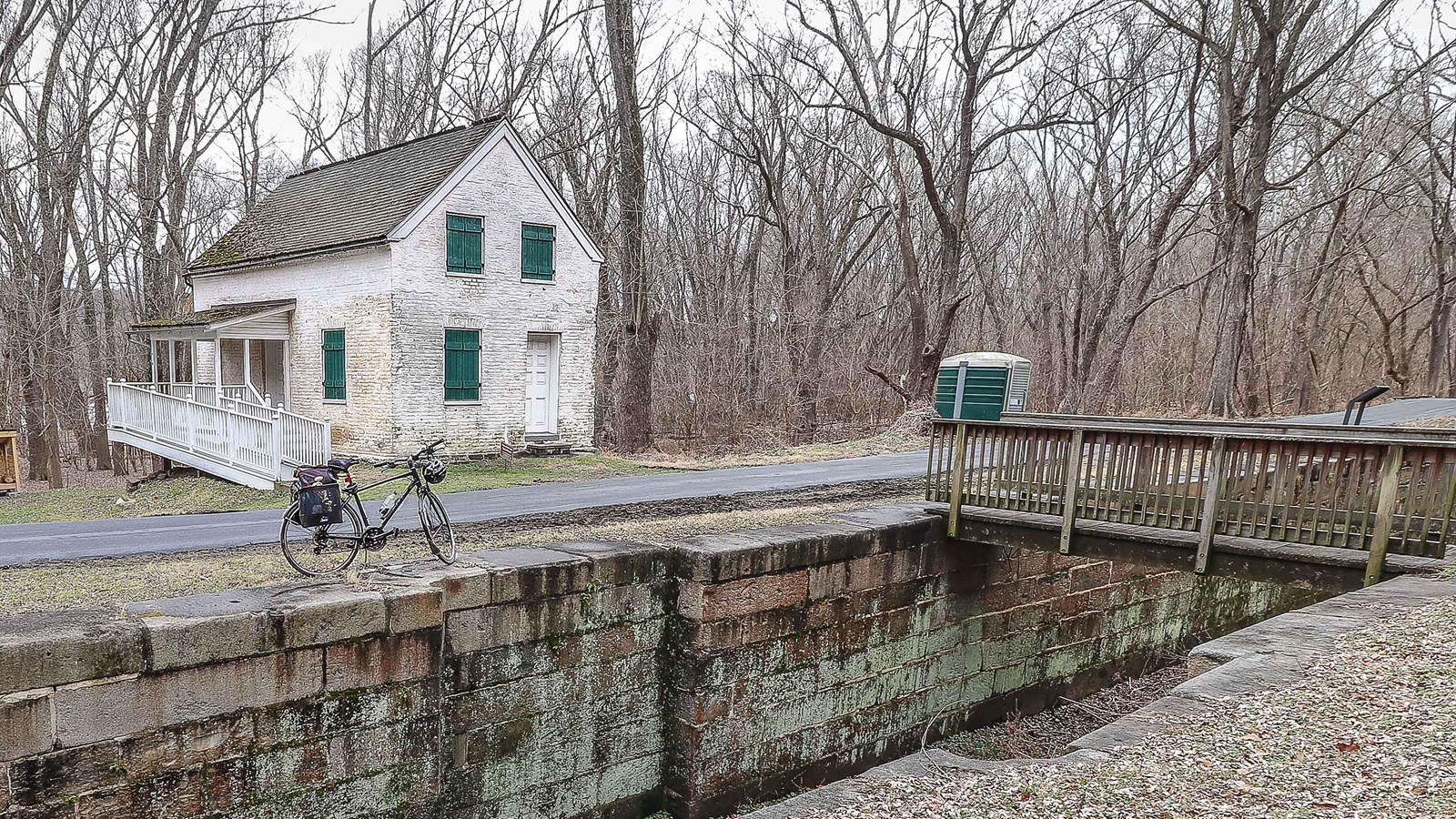 A white lockhouse sits on the far side of the canal.