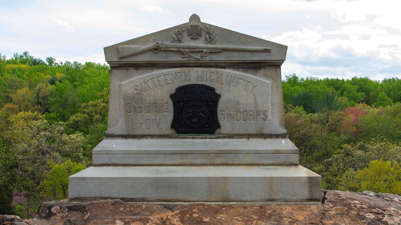 Large granite monument atop a boulder.