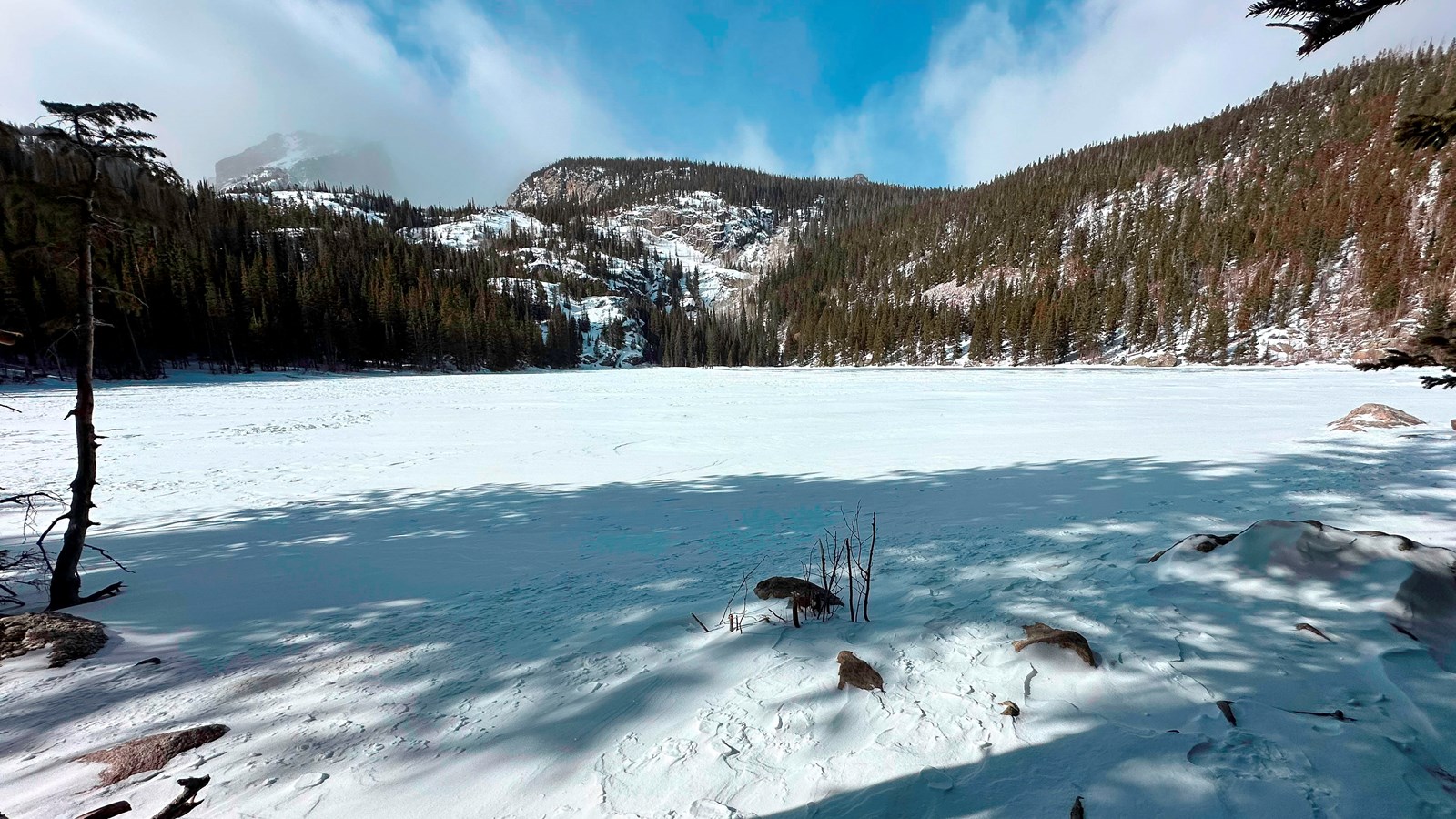 Bear Lake, the surface of the lake is frozen and covered with snow on a sunny day