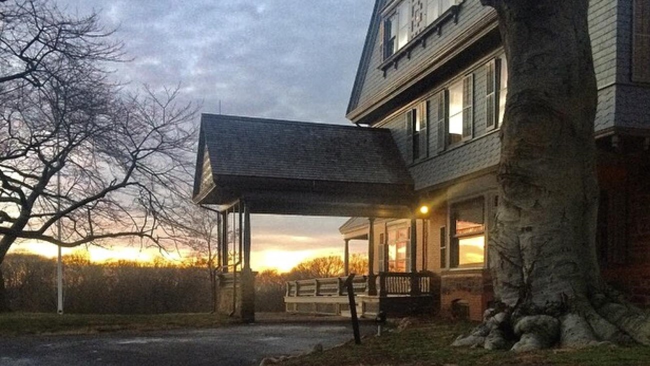 A brilliant sunset, reflecting off the front windows of Theodore Roosevelt\'s home at Sagamore Hill.