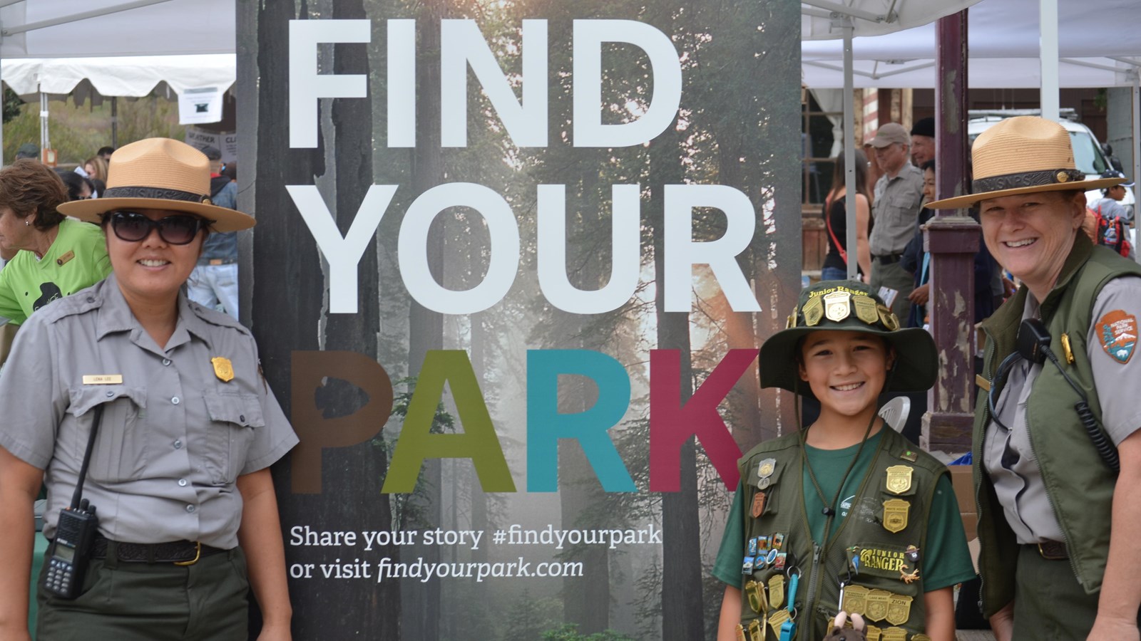 boy with two rangers standing next to sign that says find your park
