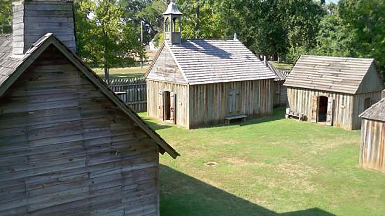 A historic fort with multiple wooden buildings.