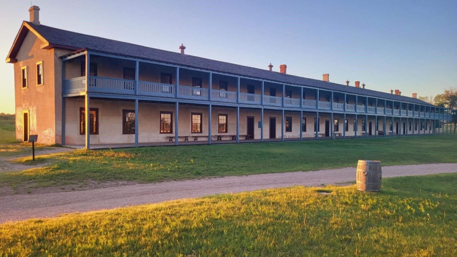 A two story cement building with a blue wood porch.  