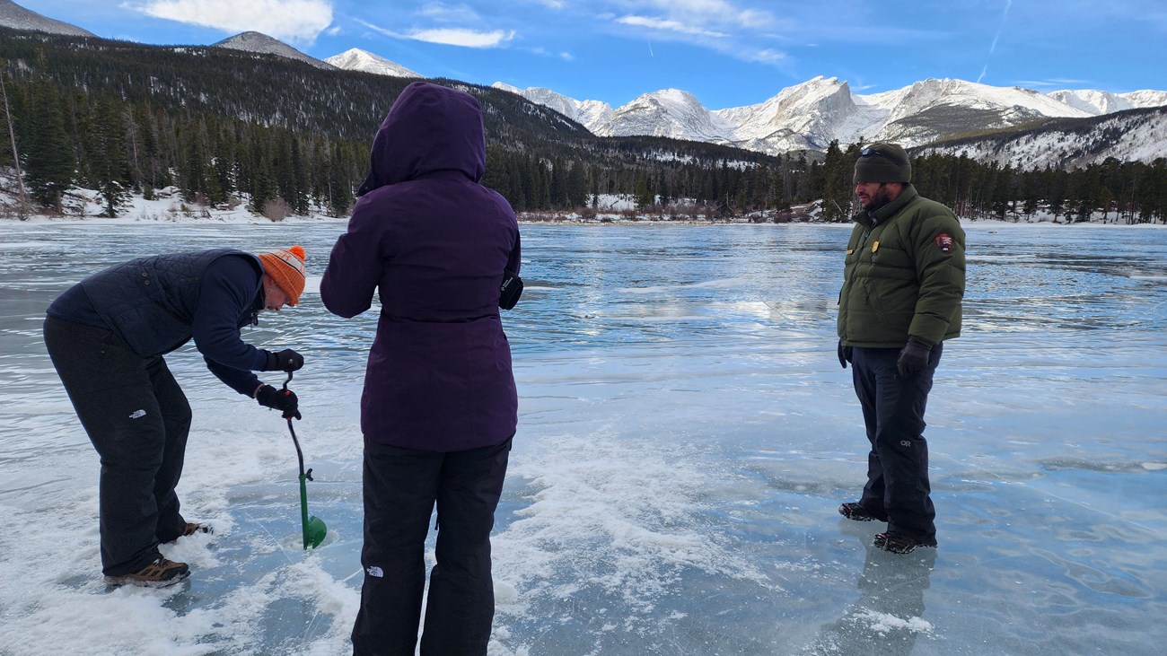 Two park visitors are trying ice fishing
