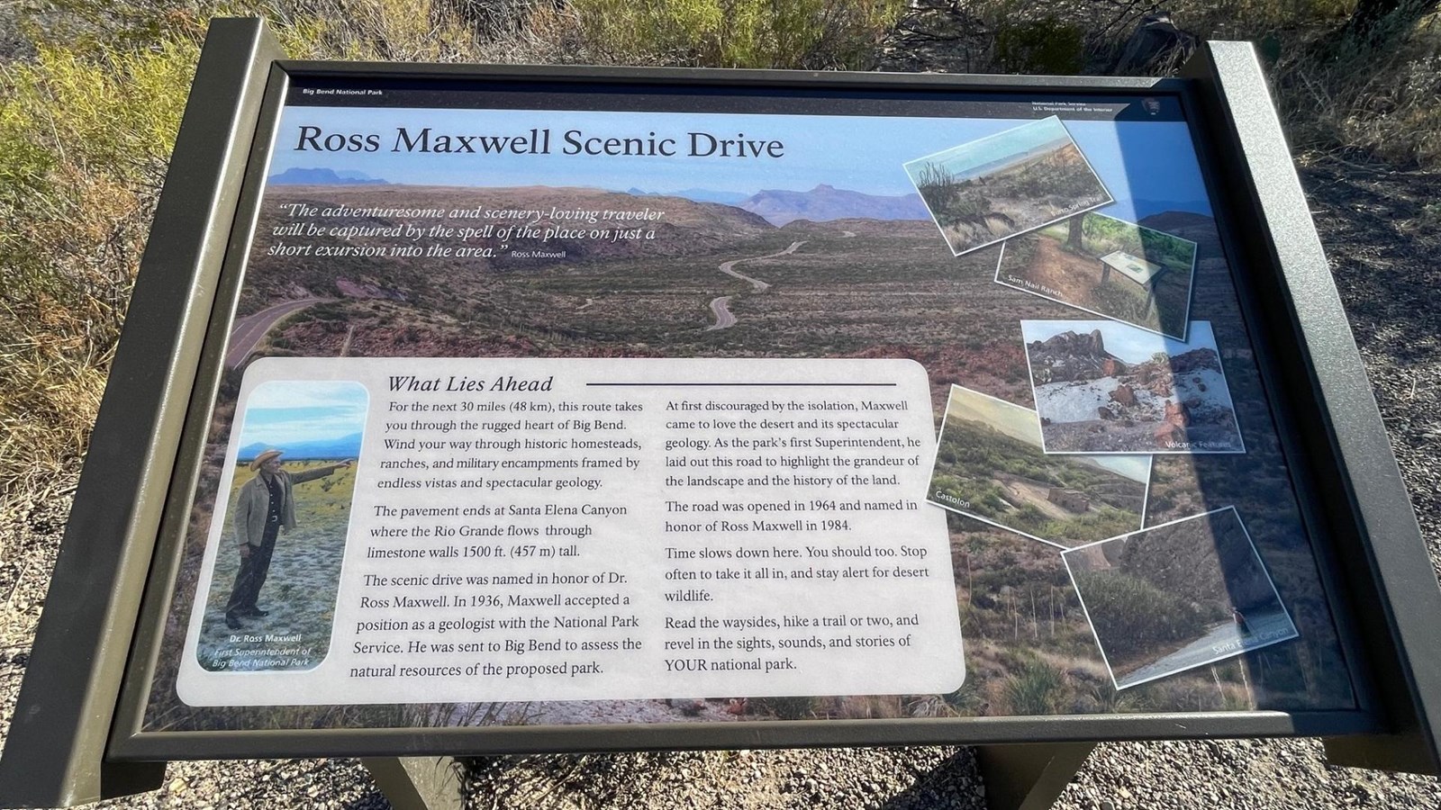 A metal sign supports an exhibit panel with text and pictures describing Ross Maxwell Scenic Drive.