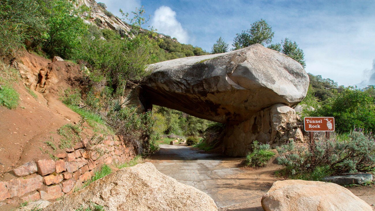 A large granite rock suspended over an old road.