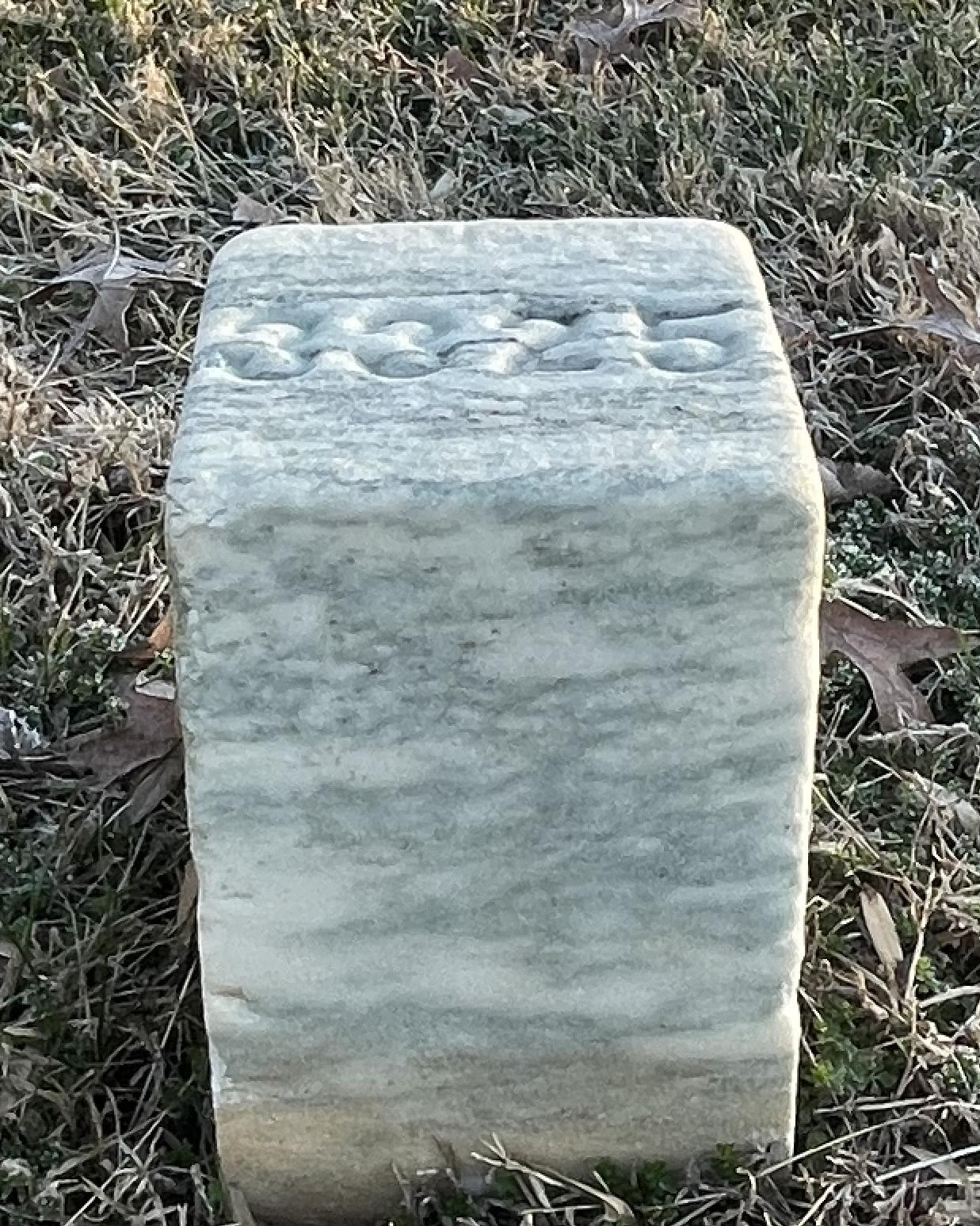 Short, cube shaped marble headstone representing the unknown graves in SRNC.