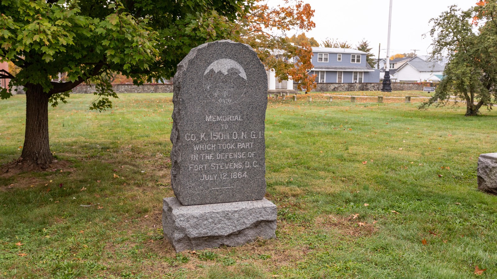 a monument in front of a grassy field. 