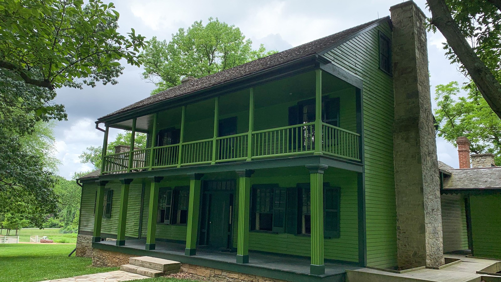A two-story green house on a summer\'s day