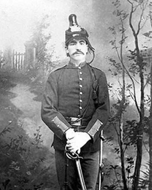 Black and white photo of African American man in 1870s formal army uniform including helmet