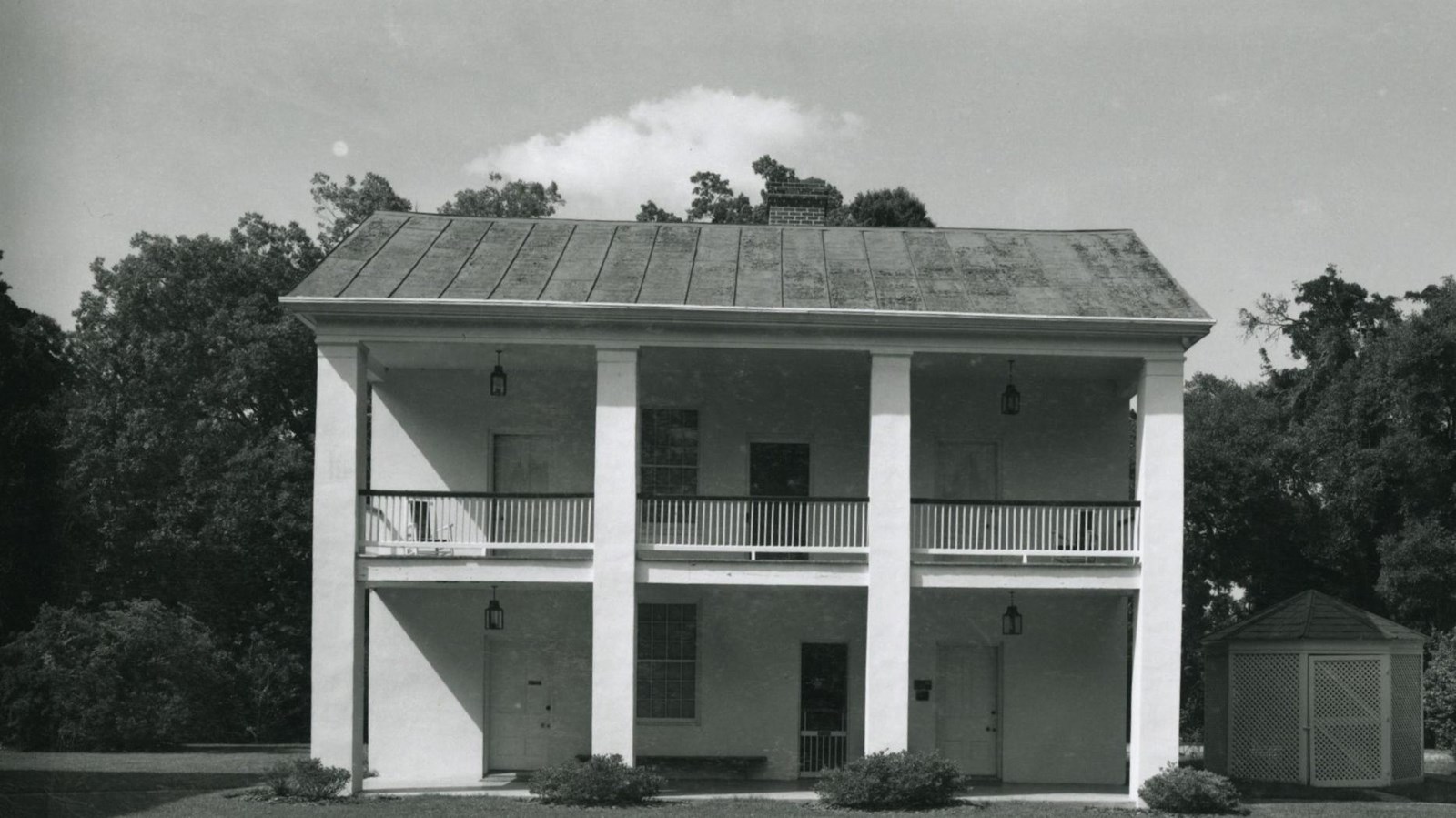 Two story brick buildings, with porches across the width of each story and four evenly spaced column