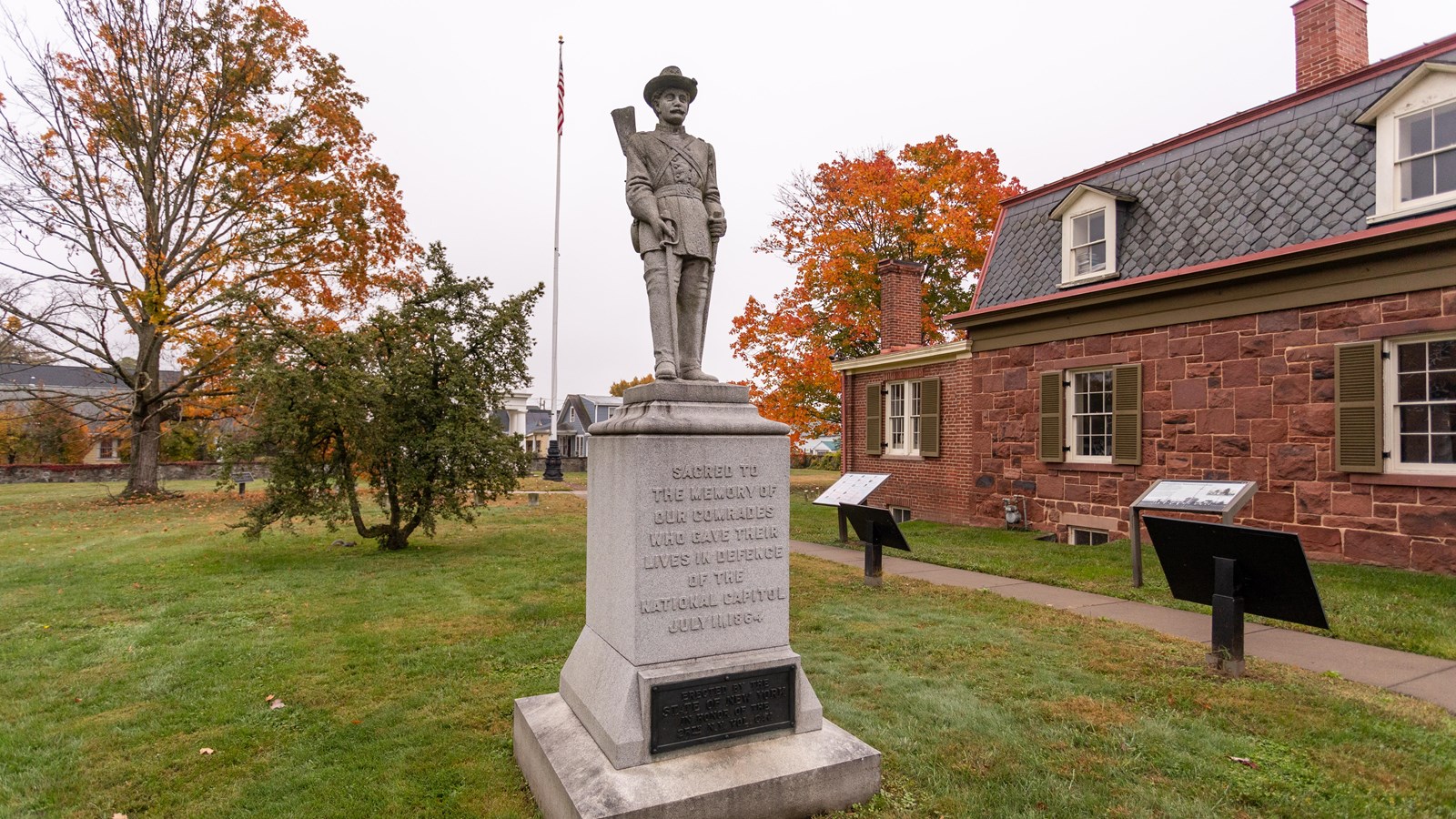 A large soldier statue in front of a house. 