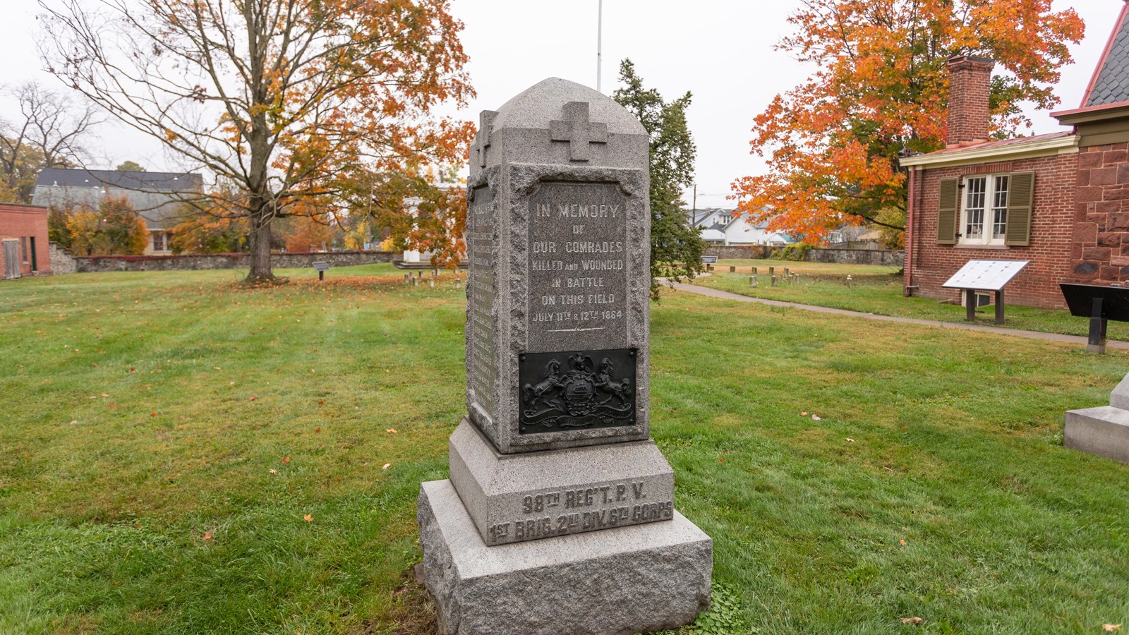 A large monument in front of a grassy field. 