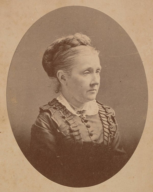 Studio portrait in oval of woman turned toward right in Victorian dress