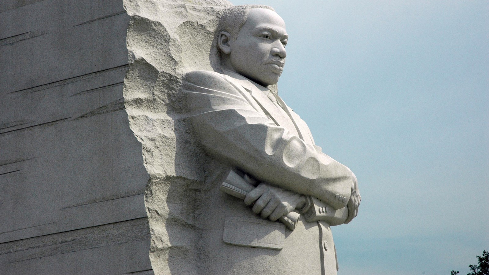 white stone structure with image of a man wearing a suit carved into the front.