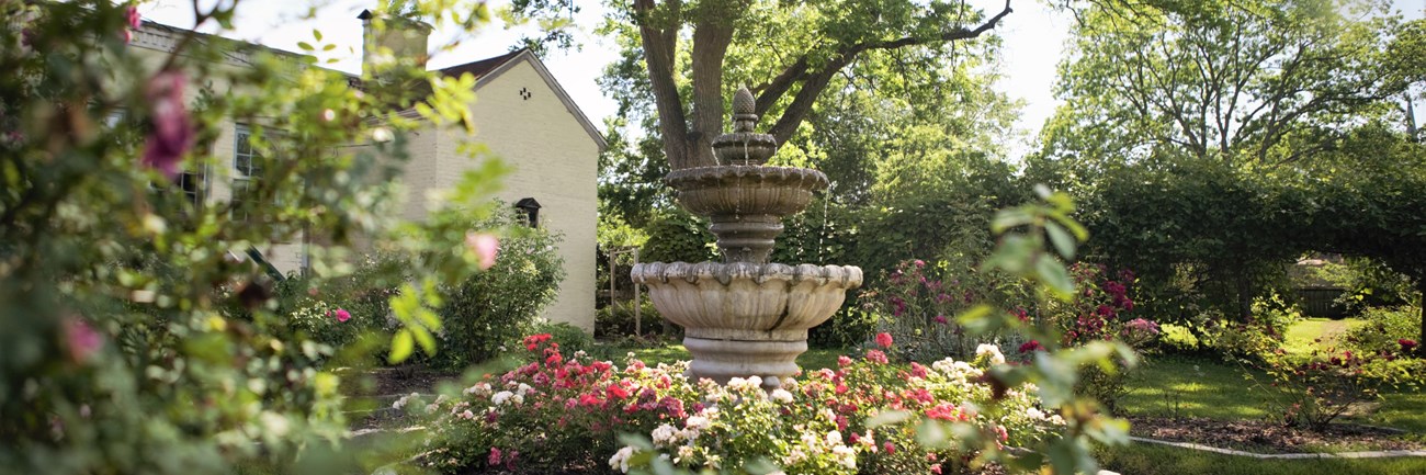 A court fountain sits in the middle of a rose garden