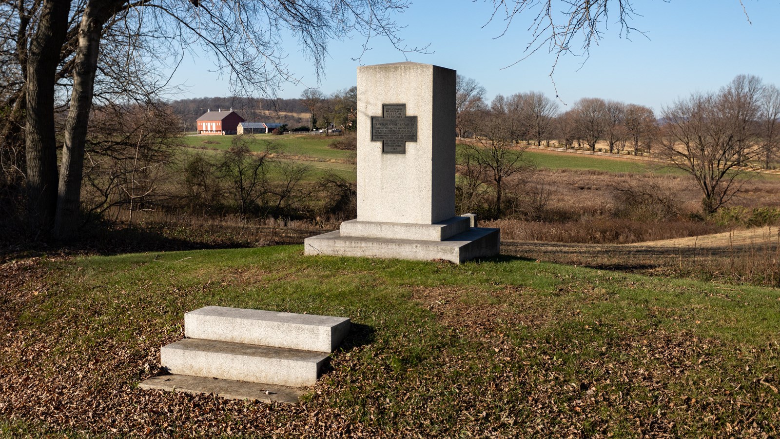 A large pillar with a cross on the top of it. 
